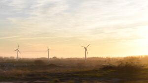 Wind turbines stand silhouetted against the golden sky.